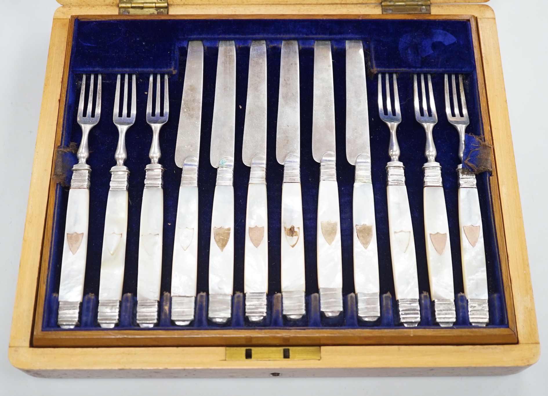 A cased set of twelve pairs of 19th century French mother of pearl handled white metal dessert eaters (one fork a.f.).
